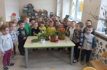 Dumnie pozujące dzieci z roślinami 