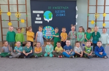 Trzylatki z transparentem na tle dekoracji z okazji Dnia Ziemi. 