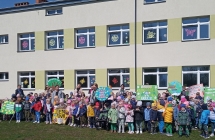 Dzieci z transparenrtami na tle budynku przedszkola. 