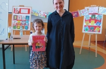 Uśmiechnięta dziewczynka i kobieta na tle obrazków 