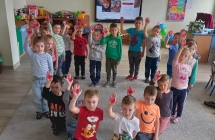 Dzieci stojące w kółku pokazujące wycięte serce na dłoniach 