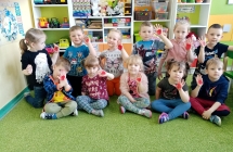 Kilkunastu dzieci w sali przedszkolnej 