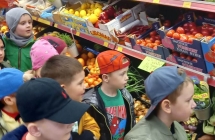 Dzieci w markecie. W tle półki z owocami 