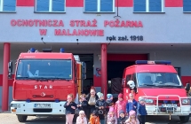 Zdjecie grupowe na tle z wozami strazackimi