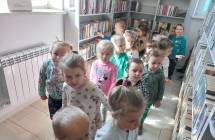 Dzieci ogladaja regaly z ksiazkami.