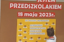 Dziewczynka sklada podpis paluszkowy na Akcie slubowania.