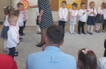 Pani dyrektor pasuje dzieci lizakiem.