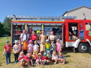 Zdjecie ze strazakami na tle wozu strazackeigo