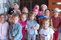 Dzieci pozuja na tle zagrod ze zwierzetami
