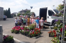 Dzieci z gr. VII z mama Natana przy stoisku z kwiatamimi warzywami