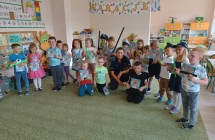 Zdjecie dzieci z policjantem z rekwizytami i w strojach.