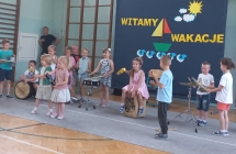 Usmiechniete dzieci graja na instrumentach perkusyjnych.
