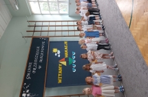 Dzieci ustawione w szeregu recytuja wiersz