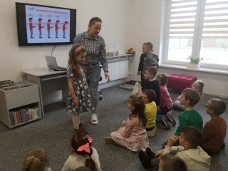 pracownik biblioteki opowiada dzieciom o skutkach zdrowotnych nadmiernego uzywania urzadzen mobilnych