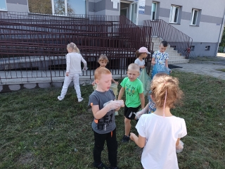 Dzieci biora udzial w akcji sprzatanie swiata, porzadkuja teren obok Osrodka Zdrowia