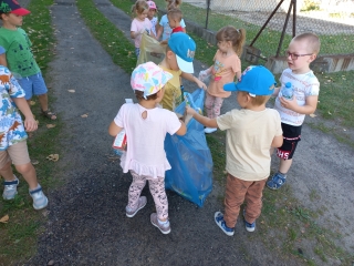 Dzieci z gr. III wrzucaja odpadki do workow do segregacji.