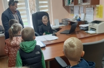 Chlopiec siedzi na fotelu pana dyrektora