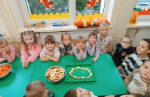 Dzieci ukladaja liyterki z owocow
