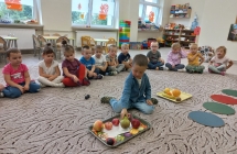 Dzieci z gr. III obserwuja  kolege segregujacego owoce.