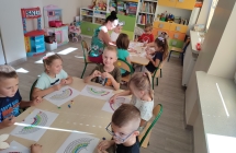Przedszkolaki przy stolikach wykejaja obrazki plastelina
