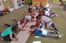 Dzieci z gr. Kotki wykonuja prace plastyczna na duzym arkuszu papieru nt. Z kropki powstalo