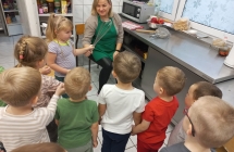 Pani pokazuje dzieciom trzepaczke.