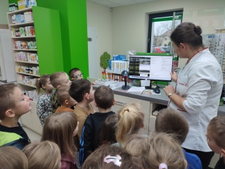 Przedszkolaki przygladaja sie pracy aptekarza