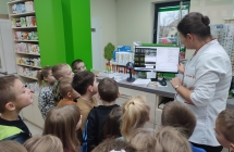 Dzieci 5,6 - letnie wsluchuja sie w opowiadanie p. farmaceutki w aptece