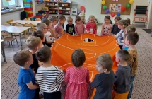 Czterolatki podczas zabawy sprawnosciowej z pilka.