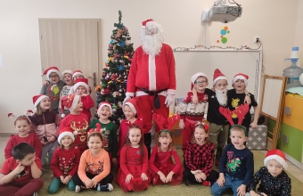 Dzieci z gr. VI z Mikolajem w sali przedszkolnej przed wystrojona choinka