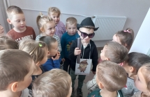 Dziecko przebrane za detektywa w otoczeniu kolegow.