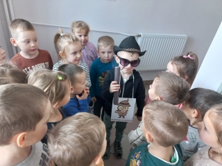 Dziecko przebrane za detektywa w otoczeniu kolegow.