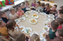 Dzieci z gr III smakuja owoce na talerzach z piramida.