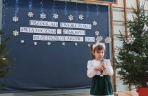 Dziewczynka śpiewa przy choince.