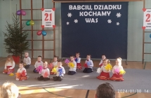 Usmiechniete dzieci z kolorowymi pomponami podczas piosenki dla babc i dziadkow.
