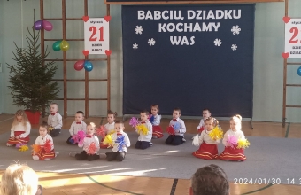 Usmiechniete dzieci z kolorowymi pomponami podczas piosenki dla babc i dziadkow.