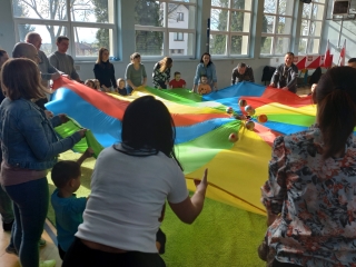 Dzieci i rodzice podczas zabawy z chusta animacyjna