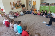 Skupione dzieci na dywanie podczas sluchania bajki.
