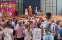 Dzieci w kolorowych kapeluszach podczas magicznej sztuczki z artystka cyrkowa.