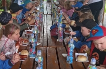 dzieci konsumuja kielbaski z ogniska