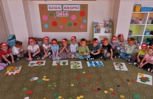 Pieciolatki z gr. VI siedza na dywanie przed ukonczonymi pracmi z kolorowych kol.