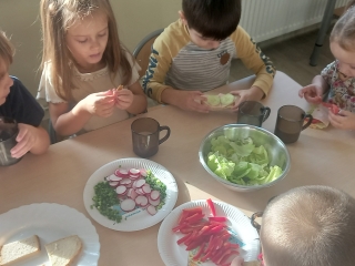 dzieci wybieraja warzywa do dekoracji swoich kanapek