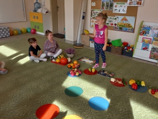 Pieciolatki na dywanie podczas zajec matematycznych z owocami i warzywami.