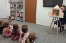 dzieci sluchaja bajki o Trzech malych swinkach technika kamishibai