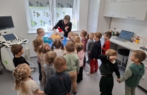 Pani weterynarz pokazuje dizeciom jak bada sie zwierzeta.