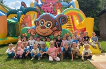 Zdjecie grupowe dzieci z gr. VI przed dmuchanym zamkiem.