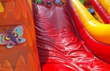 Dzieci zjezdzaja z dmuchanej zjezdzalni. Grupa IV