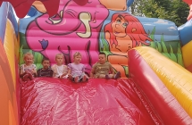 dzieci bawia sie na dmuchanym zamku