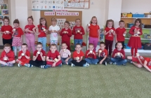 Dzieci z gr. VI w czerwonych koszulkach z kostkami dla przyjaciela.