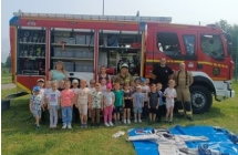 Dzieci z gr. VI ze strazakami na tle wozu strazackiego.